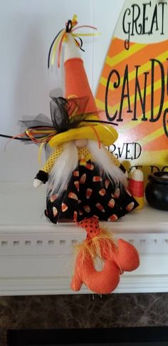 an orange and black witch hat on top of a mantle next to other halloween decorations