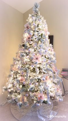 a white christmas tree with pink and blue ornaments