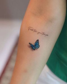 a small blue butterfly tattoo on the left arm with words above it that says, you're the best friend