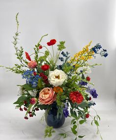 a blue vase filled with lots of colorful flowers