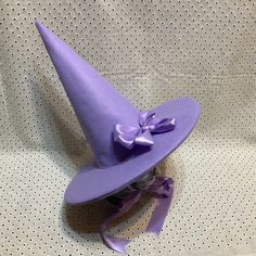 UPDATE: AUGUST 2023- These hats are now made with two layers of felt in the cone.  The double layer makes for a stronger hat which stands up on its own while still being light enough to be comfortable. Looking for a fun witch hat?  Who says that witches have to wear black?  Want to look like you stepped out of the pages of a fairy tale?  Searching for a unique hat for Halloween?  This is perfect for the practical witch who wants her hat to stay put while she soars through the night sky on her broomstick. These witch hats are made out of soft wisteria purple wool/rayon felt.  Satin ribbons tie under your chin.  Choose from a plain hat or one decorated with a matching satin bow pin.   Wool Felt is a blend of 35% wool and 65% rayon.  It's a very soft, flexible fabric which makes a lightweight Cool Witch Hats, Adjustable Flat Brim Costume Hat, Adjustable Purple Hat For Costume, Adjustable Brimmed Felt Costume Hat, Adjustable Brimmed Felt Hat For Costume, Adjustable Purple Felt Hat With Short Brim, Adjustable Costume Hat One Size, Adjustable Purple Felt Hat With Flat Brim, Adjustable Purple Top Hat With Curved Brim