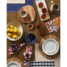 a table topped with plates and bowls filled with lemons next to other food items