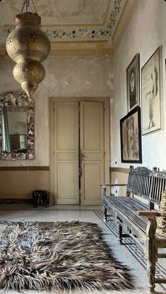 a room with a bench, mirror and pictures hanging on the wall next to it