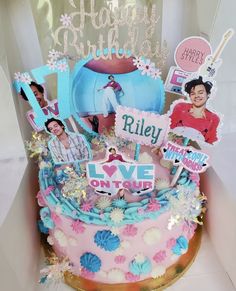 a pink and blue birthday cake with photos on it