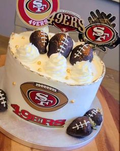 a cake decorated with chocolate covered footballs on top of a wooden table