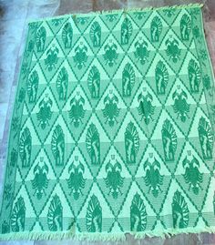 a green and white rug sitting on top of a tile floor