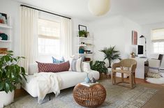 a living room filled with furniture and plants