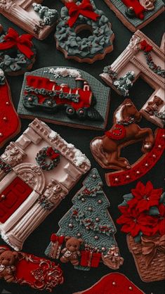 christmas cookies are arranged on a black tablecloth with red and silver decorations around them