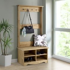 a wooden bench sitting in front of a window next to a potted plant on top of a hard wood floor