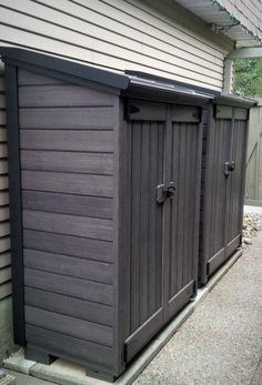 two wooden storage sheds on the side of a house