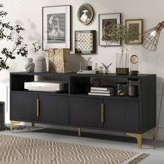 a black and gold sideboard with pictures on the wall