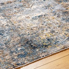 a blue and yellow rug on top of a wooden floor next to a hardwood floor