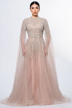 Experience understated elegance with the Noor Modest Long Drape Sleeves Beaded A-line Gown by Iyza Belaar. This evening gown features a unique blend of modesty and glamour, with long cape sleeves gracefully touching the floor and a delicate beaded bodice that seamlessly transitions into a tulle beaded skirt. Hand-embellished with meticulous attention to detail, this gown is a captivating choice for those seeking timeless sophistication at formal events. Tulle A-line Gown: The Noor Gown is crafted from a hand-embellished Tulle Overlay Fabric, offering a luxurious and ethereal quality to the dress. The partially lined bodice provides a hint of allure, while the fully lined skirt guarantees coverage. The semi-sheer unlined sleeves add a touch of delicacy, allowing you to showcase a modest yet Gowns Aesthetic, Long Drapes, Evening Gowns With Sleeves, Long Cape, Beaded Skirt, Draping Fashion, Drape Sleeves, Beaded Bodice, Cape Sleeves