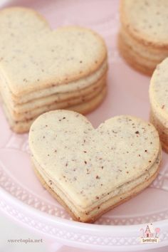 four heart shaped cookies on a pink plate