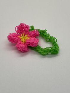 a pink and green flower sitting on top of a white table next to a pair of scissors