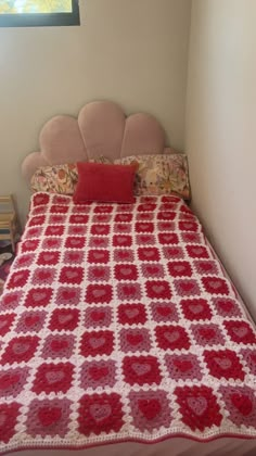 a red and white crocheted bedspread on a bed in a bedroom