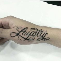 a person with a tattoo on their arm that says,'beauty'in cursive writing