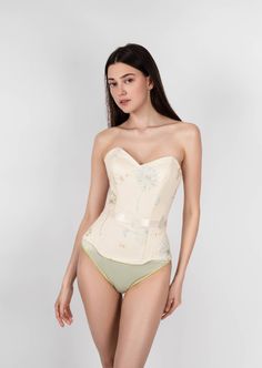 Sunlight Corset is a combination of sophistication and sunny light mood. This corset has a natural push-up effect due to the special arrangement of the bone layout and design. The corset is able to reduce the waist and hips, creating the perfect hourglass silhouette that makes you more feminine. The corset is made of high-quality French satin and transparent net hand-embroidered with sky blue and golden dandelions. It also has transparent paillettes (recycled plastic) imitating the morning dew. Hourglass Silhouette, Morning Dew, The Bone, Corsets, Recycled Plastic, Sky Blue, Hand Embroidered, Push Up, Sunnies