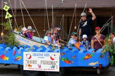 children are riding in the back of a boat made out of paper boats and sticks