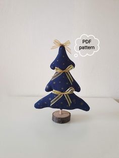 a small blue christmas tree with gold ribbons on it and a thought bubble above it