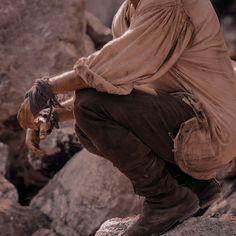 a man sitting on top of a pile of rocks