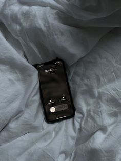 an iphone laying on top of a bed covered in white sheets with the text every day written on it