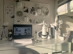 a laptop computer sitting on top of a desk next to a white shelf filled with stuffed animals