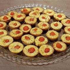 there are many small muffins in the glass dish on the table, ready to be eaten