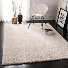 a white rug in a living room next to a chair