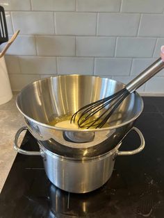 a large metal bowl with whisk in it