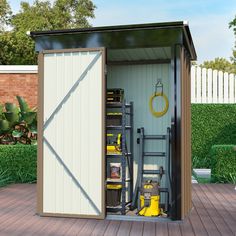 an outhouse with its doors open and tools in the storage compartment on the deck