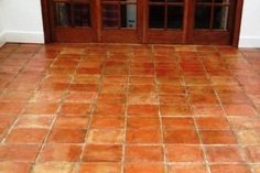 a tile floor in front of a door with glass panes on the doors and windows