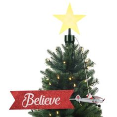 a small christmas tree with an airplane on it and a believe sign hanging from the top