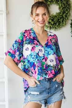 Floral print boxy top with a V-neckline and short sleeves.- Unlined, non-sheer, lightweight.- Model is 5'8'' and is wearing a Small. 100% Polyester Trendy V-neck Blouse With Graphic Print, Casual Floral Print V-neck Top For Summer, Trendy V-neck Blouse With Vibrant Print, Summer V-neck Tops With Multicolor Print, Spring Casual Flowy V-neck Top, Casual Summer V-neck Top With Floral Print, Flowy V-neck Summer Top, Casual Floral Print Short Sleeve V-neck Top, Spring V-neck Top For Day Out