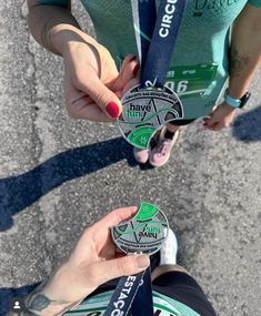 two people holding up medals in their hands