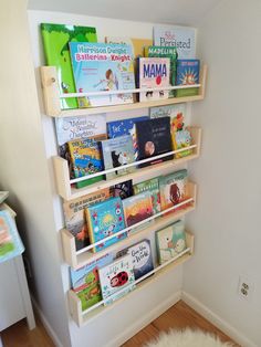 the bookshelf is full of children's books and has a white rug on the floor