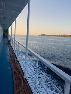 the back deck of a ship with ropes on it's railing and water in the background