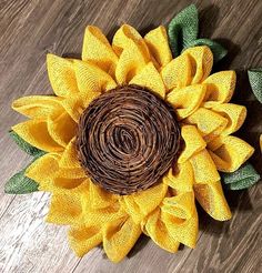 a sunflower made out of burlock on top of a wooden floor