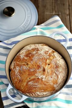 a loaf of bread sitting in a pan on top of a blue and white towel