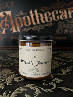 a jar of witch's journal jam sitting on top of a black tablecloth