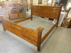 a bed frame made out of bamboo in a room with other furniture and mirrors on the walls