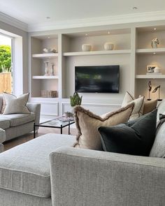 a living room filled with furniture and a flat screen tv mounted to the wall above it