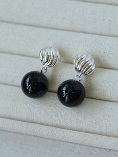 These elegant earrings are crafted with sterling silver posts and pendants made of black onyx, a striking gemstone known for its deep, mysterious hues and unique patterns. The onyx gemstones are expertly cut and polished to enhance their natural beauty, creating a sophisticated and timeless accessory. These earrings combine modern style with classic elegance. Metal: Recycled Sterling Silver Plated On Brass /925 Sterling Silver Ear Needle Gemstone: Black Onyx 14mm Earrings Length: 30mm Single Wei Elegant Black Clip-on Earrings For Gift, Black Onyx Round Earrings, Black Sterling Silver Earrings For Formal Occasions, Black Onyx Earrings With Polished Finish, Modern Black Sterling Silver Earrings, Elegant Black Drop Clip-on Earrings, Nickel-free Black Onyx Earrings, Black Polished Earrings For Evening, Black Polished Finish Earrings For Evening