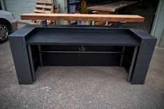 a black desk with a wooden top sitting in front of a garage