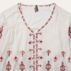 This top offers a soft and flowing silhouette with bohemian embroidered detailing throughout, including subtly hidden buttons at the front. A relaxed choice for brunch, a music festival, or wherever else the season takes you. 100% Viscose 3/4 Elastic Gathered Sleeves Curved Front and Straight Back Yokes Self-Covered Button Front Imported Bohemian V-neck Embroidered Top, Bohemian V-neck Blouse With Embroidered Hem, Bohemian Peasant Top With Embroidered Neckline, Casual Embroidered Rayon Blouse, Bohemian Embroidered Top With Boho Collar For Spring, Bohemian Spring Tops With 3/4 Sleeves, Bohemian Long Sleeve Embroidered Top For Vacation, Bohemian Rayon Blouse For Spring, Rayon Tops For Fall Festival