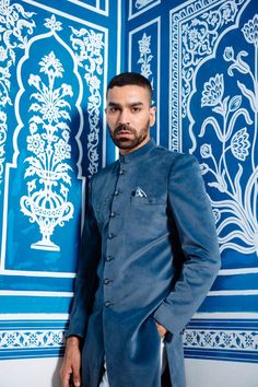 "Product Description Make an edgy statement with our Obtuse Blue Velvet Indo Western designed thoughtfully for the modern Indian man. A fusion staple fit for every occasion, adds the right amount of cultural twist to the western silhouette. Color: Obtuse Blue Garment Type: Indo Western Neck: Mandarin Collar Fabric: Micro Velvet Embroidery: Sequin Work Patch The Product Price is inclusive of: 1 Indo-Western and 1 Trouser Style Bottom Model is 6'2\" wearing Size 38 Product color may slightly vary due to photographic lighting sources or your screen settings." Jodhpuri Sherwani For Men, Jodhpuri Sherwani, Indo Western For Men, Indian Jackets, Sherwani For Men Wedding, Jodhpuri Suit, Sherwani For Men, Men's Ethnic Wear, Indian Man