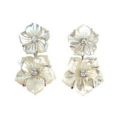 These exquisite Carved Mother of Pearl Floral Earrings are a perfect addition for any fashionista's wardrobe. Hand-crafted from double carved Mother of Pearl, these earrings are sure to make a delicate yet stylish statement. Perfect for any special occasion, these earrings are truly a luxurious piece of art. Small Double Carved Mother of Pearl Flower Drop Earrings Carved mother of pearl flower Round simulated diamond Hand set in sterling silver Available in 18k yellow gold vermeil or platinum rh Luxury Silver Sterling Silver Flower Earrings, Luxury Pearl White Mother Of Pearl Earrings, Luxury White Gold Flower Earrings, Luxury White Gold Flower-shaped Earrings, Luxury Classic White Flower Earrings, Luxury White Flower-shaped Pearl Earrings, Luxury White Flower-shaped Jewelry, Luxury White Flower Shaped Jewelry, Luxury Pierced Flower Earrings For Anniversary