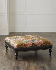 a foot stool sitting on top of a hard wood floor next to a white wall