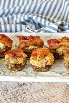 mini bacon and cheese muffins on a white platter with a striped towel in the background