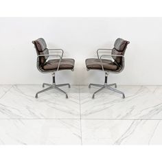 two office chairs sitting next to each other on top of a white marble countertop